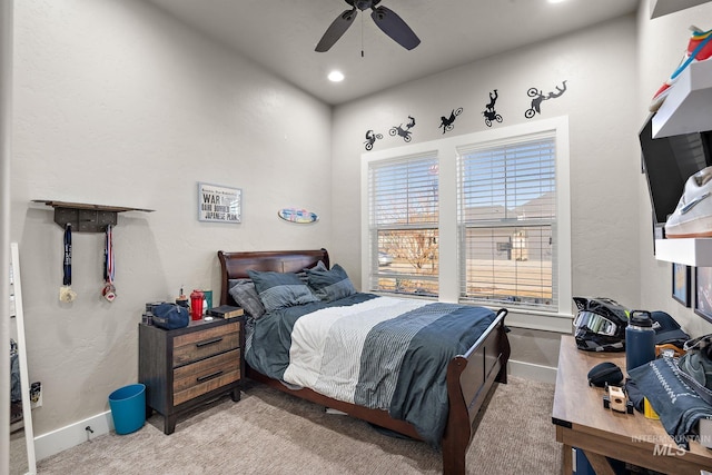 bedroom with light carpet, ceiling fan, and baseboards