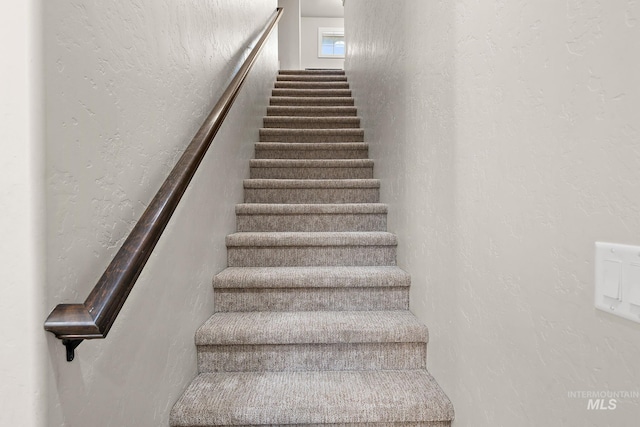 stairway featuring a textured wall