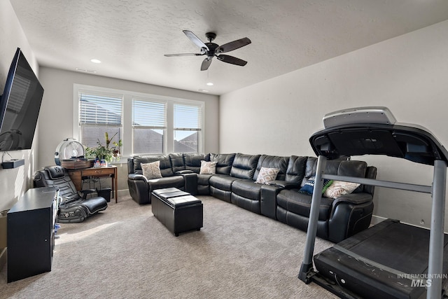 carpeted living room featuring ceiling fan, visible vents, and a textured ceiling