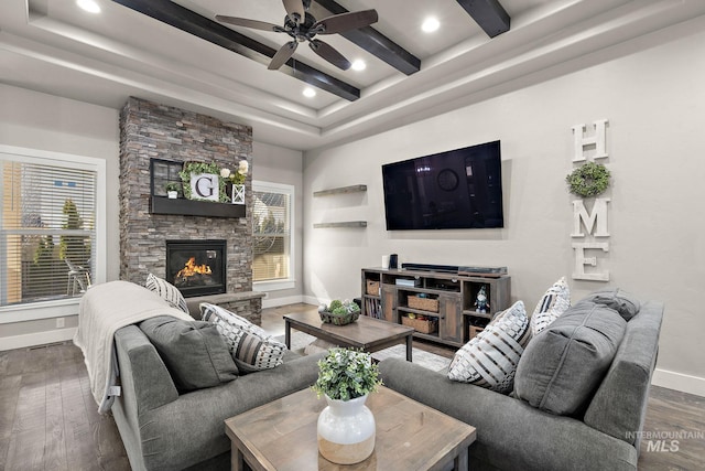 living room featuring a fireplace, baseboards, wood finished floors, and beamed ceiling