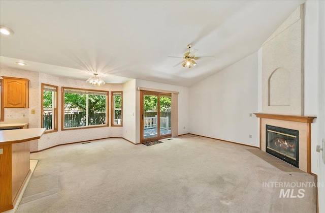 900 N Player Ave, Eagle, ID 83616 - unfurnished living room with light colored carpet, a tiled fireplace, healthy amount of natural light, lofted ceiling, and recessed lighting