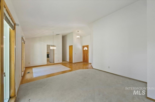 900 N Player Ave, Eagle, ID 83616 - carpeted spare room with vaulted ceiling, a chandelier, baseboards, and wood finished floors