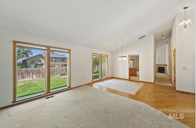 900 N Player Ave, Eagle, ID 83616 - unfurnished living room featuring a chandelier, plenty of natural light, vaulted ceiling, a fireplace, and baseboards