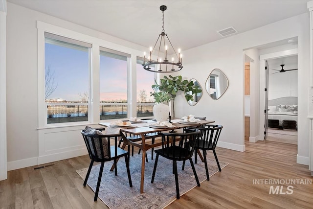 dining space with light wood finished floors, baseboards, and visible vents