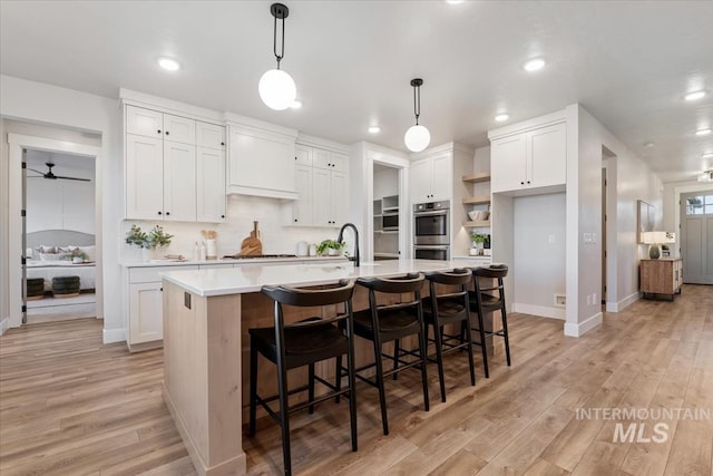 kitchen featuring light countertops, light wood-type flooring, and white cabinetry