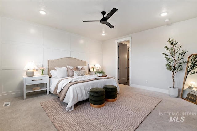 bedroom with baseboards, carpet, a ceiling fan, and a decorative wall