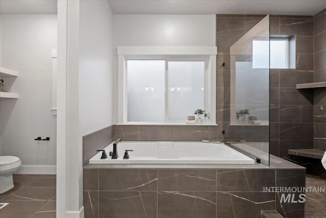 bathroom featuring toilet, a garden tub, tile patterned flooring, and baseboards