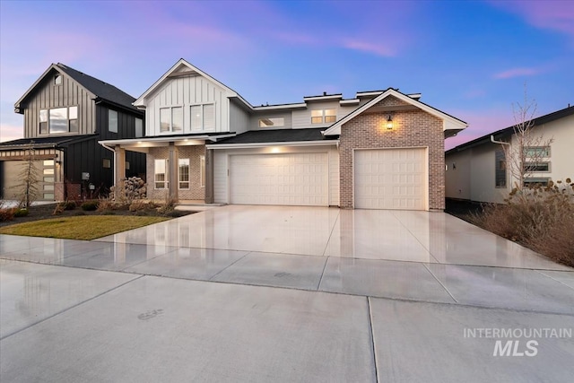 modern farmhouse with board and batten siding, brick siding, driveway, and an attached garage