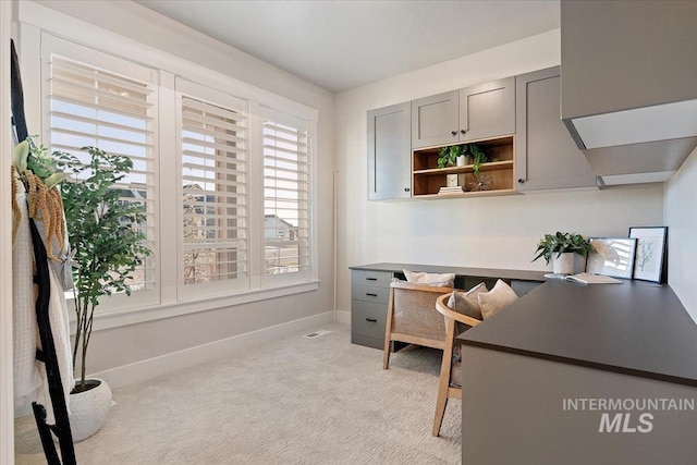 office space featuring baseboards and light colored carpet