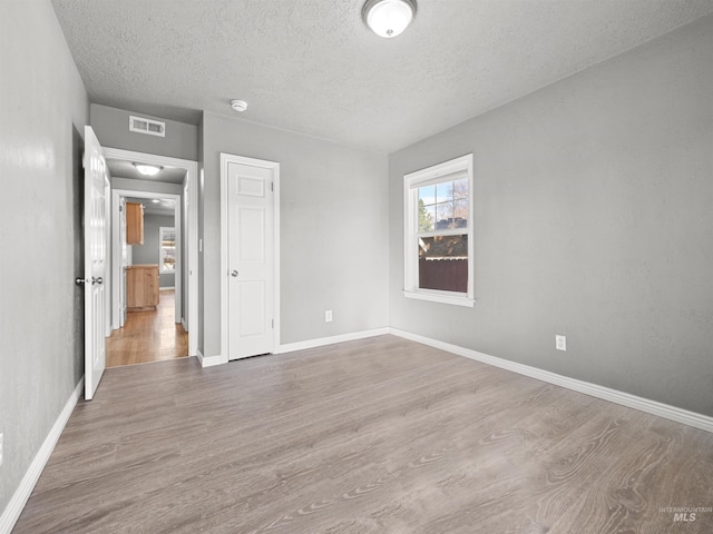 3500 W Overland, Boise, ID 83705 - unfurnished bedroom with visible vents, a textured ceiling, baseboards, and wood finished floors