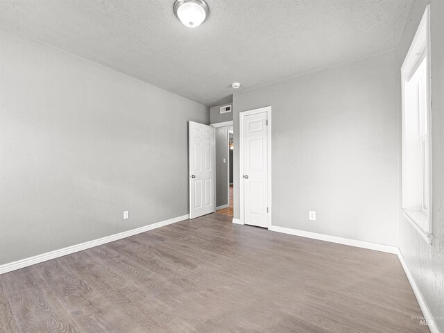 3500 W Overland, Boise, ID 83705 - empty room with visible vents, a textured ceiling, baseboards, and wood finished floors