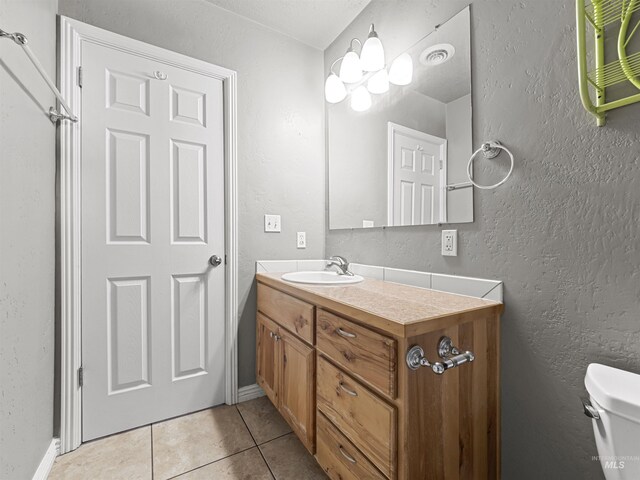 3500 W Overland, Boise, ID 83705 - bathroom with tile patterned floors, toilet, vanity, baseboards, and a textured wall