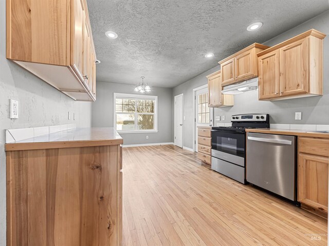 3500 W Overland, Boise, ID 83705 - kitchen featuring light wood-style flooring, stainless steel appliances, light brown cabinets, under cabinet range hood, and tile countertops