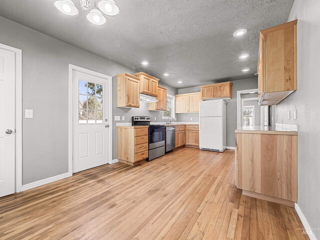 3500 W Overland, Boise, ID 83705 - kitchen featuring light countertops, stainless steel appliances, light brown cabinetry, under cabinet range hood, and light wood-style floors