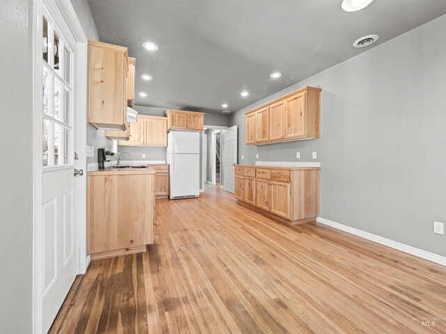 3500 W Overland, Boise, ID 83705 - kitchen with light countertops, visible vents, light wood-type flooring, light brown cabinetry, and freestanding refrigerator