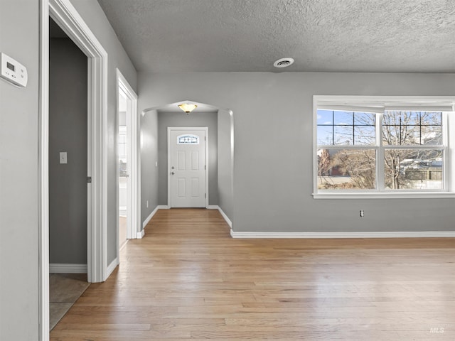 3500 W Overland, Boise, ID 83705 - foyer entrance with arched walkways, baseboards, a textured ceiling, and light wood-style flooring