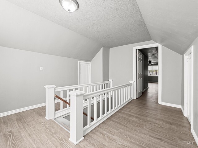 3500 W Overland, Boise, ID 83705 - corridor with an upstairs landing, lofted ceiling, baseboards, a textured ceiling, and wood finished floors