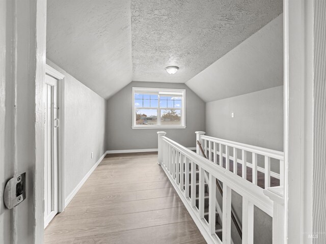 3500 W Overland, Boise, ID 83705 - hall with vaulted ceiling, an upstairs landing, wood finished floors, a textured ceiling, and baseboards