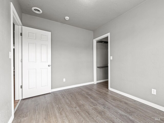 3500 W Overland, Boise, ID 83705 - unfurnished bedroom featuring wood finished floors, a textured ceiling, baseboards, and visible vents