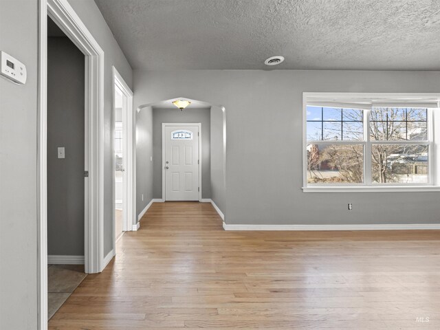 3500 W Overland, Boise, ID 83705 - entryway featuring baseboards, light wood-type flooring, arched walkways, and a textured ceiling