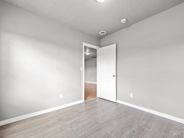 3500 W Overland, Boise, ID 83705 - unfurnished room with a textured ceiling, baseboards, and wood finished floors