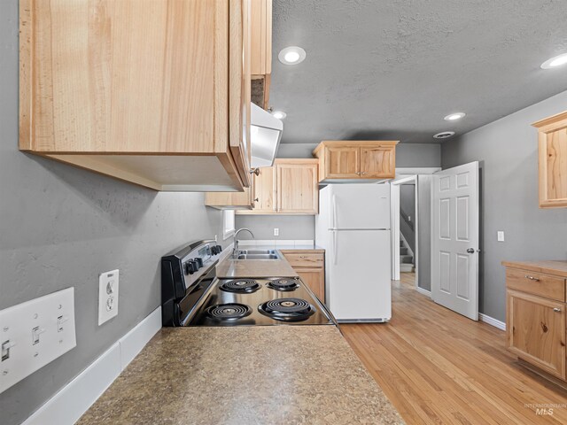 3500 W Overland, Boise, ID 83705 - kitchen with light wood-type flooring, electric range, light brown cabinets, and freestanding refrigerator