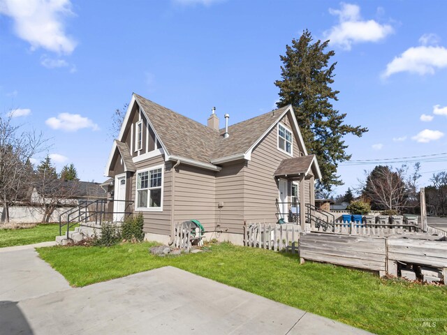 3500 W Overland, Boise, ID 83705 - view of side of home featuring a patio, roof with shingles, and a lawn