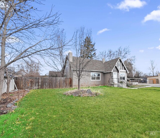 3500 W Overland, Boise, ID 83705 - exterior space featuring a lawn, a shingled roof, fence, and a chimney