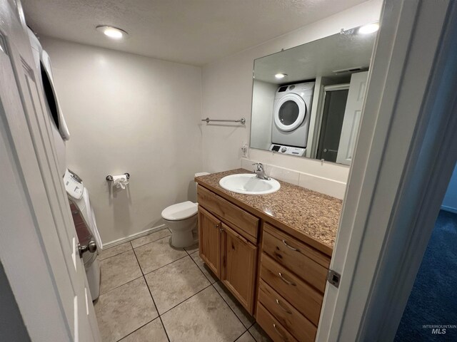 3500 W Overland, Boise, ID 83705 - bathroom featuring tile patterned floors, toilet, stacked washer / drying machine, vanity, and a textured ceiling