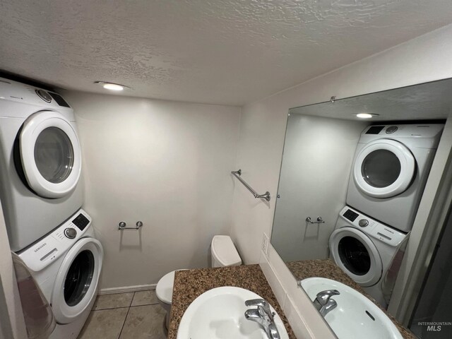 3500 W Overland, Boise, ID 83705 - washroom featuring light tile patterned floors, stacked washing maching and dryer, laundry area, and a textured ceiling