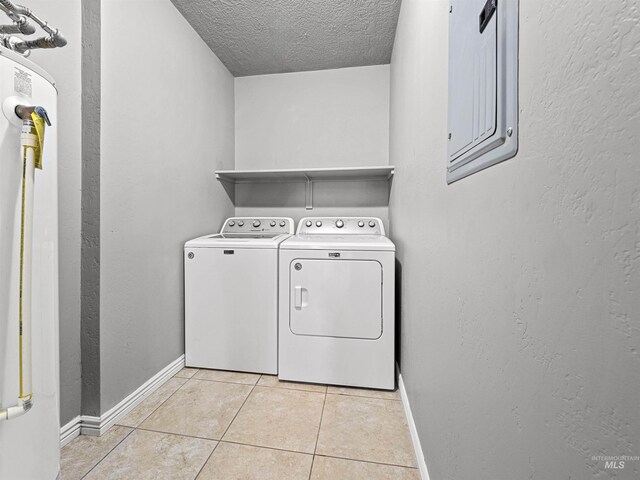 3500 W Overland, Boise, ID 83705 - clothes washing area with washing machine and clothes dryer, a textured ceiling, laundry area, light tile patterned floors, and baseboards