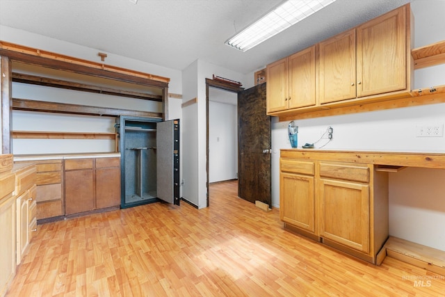 kitchen featuring light wood finished floors, light countertops, and open shelves