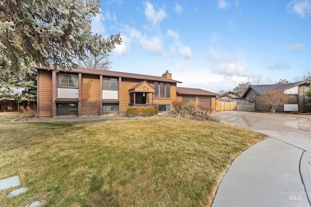 raised ranch featuring a chimney, a front lawn, and fence