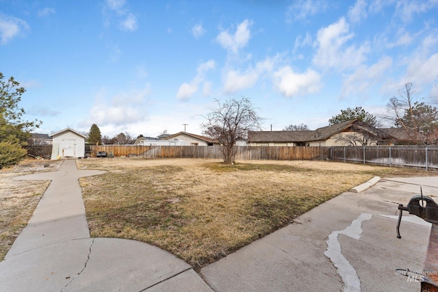 view of yard featuring an outbuilding, a storage shed, a patio, and a fenced backyard