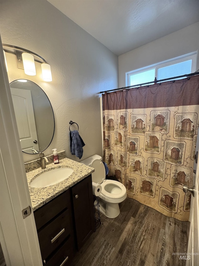 bathroom with a shower with shower curtain, vanity, hardwood / wood-style flooring, and toilet