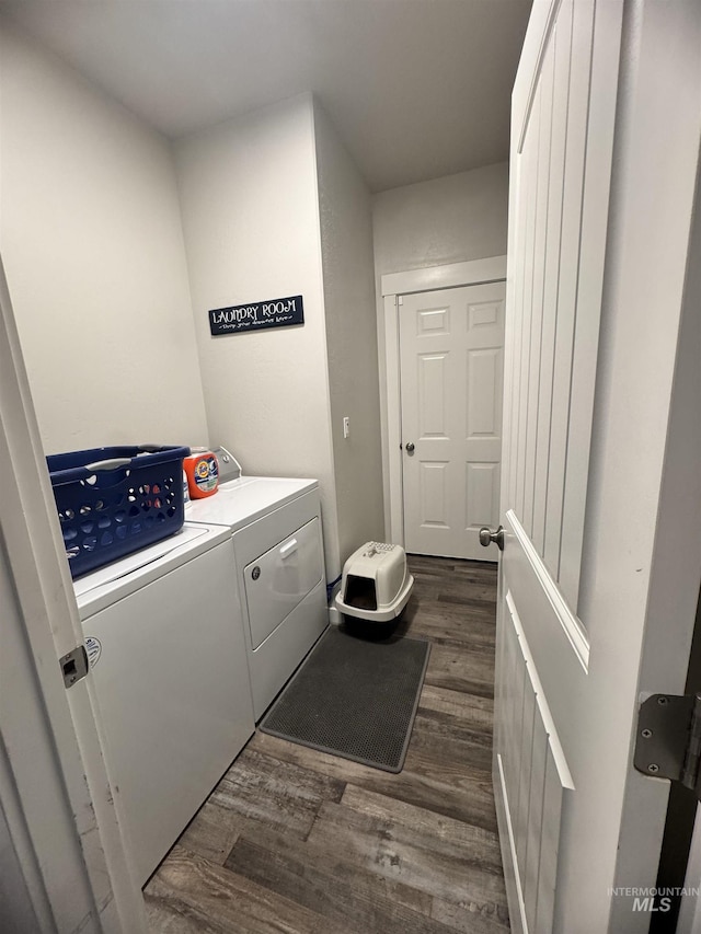 clothes washing area with dark hardwood / wood-style flooring and washer and dryer