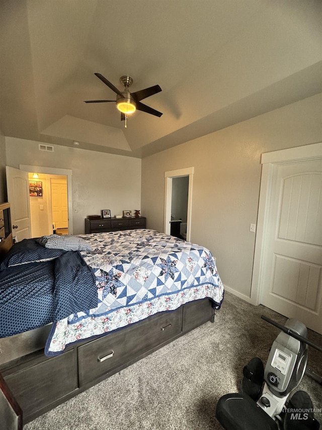 carpeted bedroom with ceiling fan, lofted ceiling, and a tray ceiling