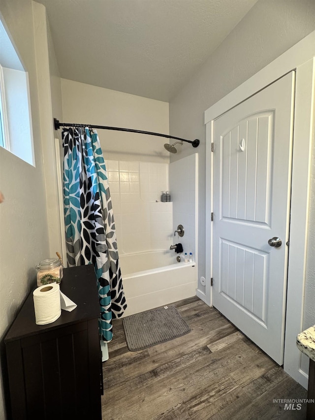 bathroom featuring wood-type flooring and shower / tub combo