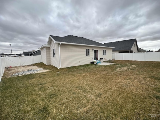 rear view of property featuring a yard and a patio