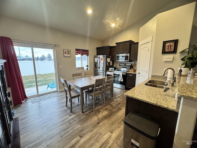 dining space featuring hardwood / wood-style flooring, lofted ceiling, and sink