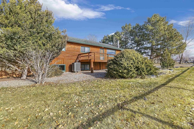 rear view of property featuring a yard, central AC unit, and a wooden deck