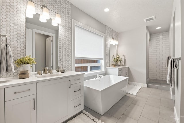 full bath featuring tile patterned flooring, a sink, tiled shower, a soaking tub, and double vanity