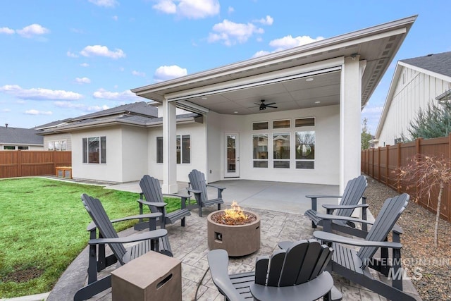 back of house with a ceiling fan, an outdoor fire pit, a fenced backyard, and a patio