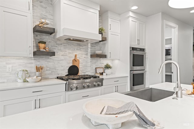 kitchen with open shelves, stainless steel appliances, white cabinets, a sink, and premium range hood