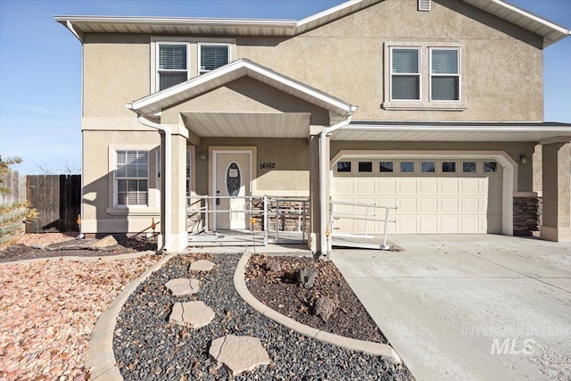 traditional-style home with stucco siding, a garage, covered porch, and concrete driveway