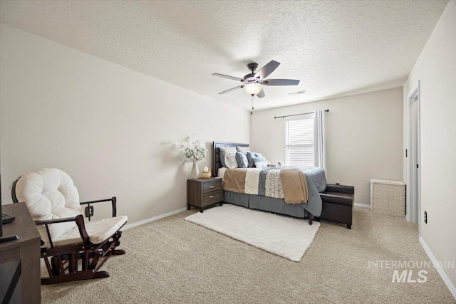 bedroom with visible vents, a ceiling fan, a textured ceiling, carpet flooring, and baseboards