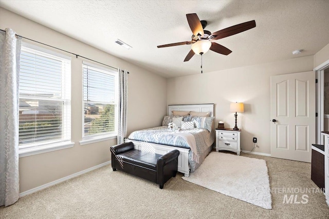 bedroom featuring visible vents, baseboards, carpet floors, a textured ceiling, and a ceiling fan