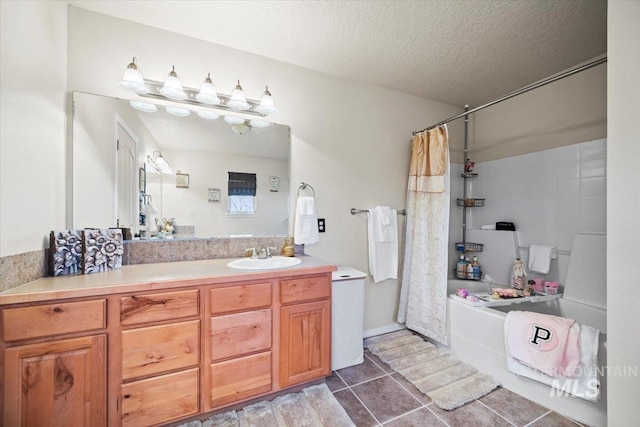 bathroom with vanity, tile patterned floors, shower / tub combo with curtain, and a textured ceiling