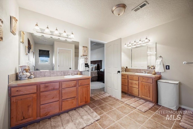 full bathroom featuring tile patterned floors, visible vents, ensuite bathroom, a textured ceiling, and vanity