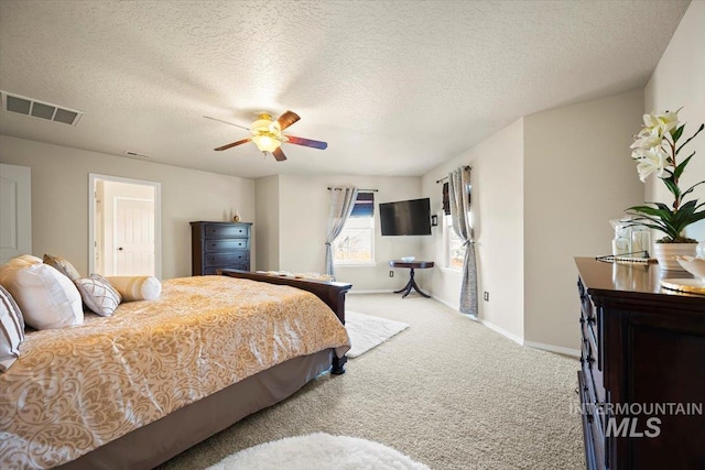 bedroom with visible vents, a ceiling fan, a textured ceiling, carpet flooring, and baseboards